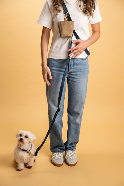 Adjustable denim dog leash with brass D-ring for attaching treat bag and accessories.