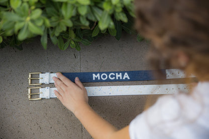 Personalized white leather dog collar with a custom denim sleeve, front view.